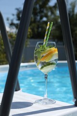 Poster - Tasty cocktail in glass near swimming pool outdoors