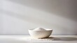 © Putt_Sanplee - A minimalist still life arrangement featuring a simple white ceramic bowl overflowing with cornflour