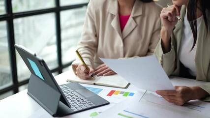 Wall Mural - Teamwork process Two businesswomen are discussing income analysis. Analyze charts Growth in financial business online marketing Calculating income, operating results, business planning.