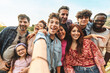 © Lomb - Diverse group selfie, joyful friends and family outdoors, multicultural gathering with genuine laughter
