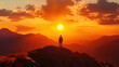 © Worakit - A person stands on mountain peak, silhouetted against vibrant sunset with warm orange and yellow hues illuminating sky.