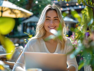 Wall Mural - A woman is sitting at a table with a laptop in front of her. She is smiling and she is enjoying herself