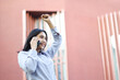 © M Alfan Setyawan - happy asian businesswoman talking on smartphone celebrate winning victory by raising fist say yes gesture wear formal shirt, insurance agent making business call in front of city building