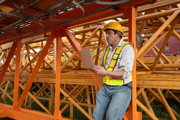 Asia engineer man worker use tablet computer checking spare crane at construction site