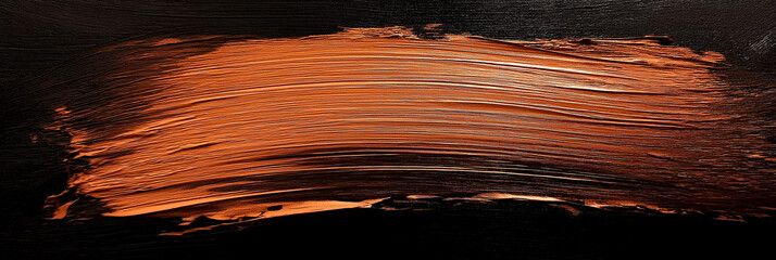 bright brown brush stroke of paint on black background