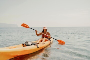 Kayak sea woman. Happy attractive woman with long hair in red swimsuit, swimming on kayak. Summer holiday vacation and travel concept.