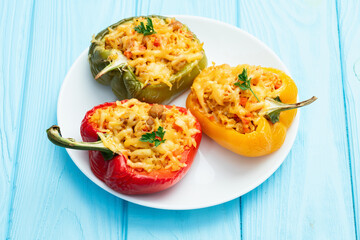 Wall Mural - Baked stuffed pepper ( paprika ) with rice , carrot and meat . Top view on rustic background