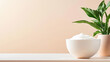 © M - White ceramic bowl filled with whipped cream on a minimalistic table next to a green potted plant against a pastel background