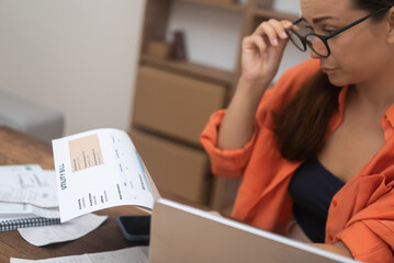  woman, at home, distressed by a utility bill, contemplates mortgage payment challenges and escalating debt.