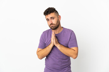 Caucasian man isolated on white background keeps palm together. Person asks for something