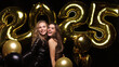 © ty - Happy gorgeous girls in stylish sexy party dresses holding gold 2025 balloons, having fun at New Year's Eve Party.