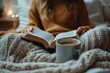 © Lubos Chlubny - Woman enjoying cozy moment reading book and drinking coffee
