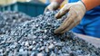 © Moopingz - Close-up of gloved hands sorting and handling crushed metal pieces, likely used in industrial or manufacturing processes.