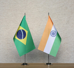 Table flags of Brazil and India on grey blurred background