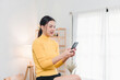 © PRIME STOCK LAB - Asian woman working on smartphone at cozy home.