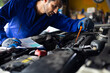 © NVB Stocker - Close up hand hispanic latin male mechanic repairs car in garage. Closeup hand. Auto car mechanic checking the oil level of the car engine. Car repair and maintenance