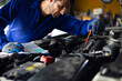 © NVB Stocker - Close up hand hispanic latin male mechanic repairs car in garage. Closeup hand. Auto car mechanic checking the oil level of the car engine. Car repair and maintenance