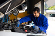 © NVB Stocker - hispanic latin male mechanic repairs car in garage. Closeup hand. Auto car mechanic checking the oil level of the car engine. Car repair and maintenance