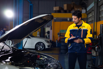 Hispanic latin man mechanic repairs car in garage. Car maintenance and auto service garage concept. Closeup hand and spanner. Insurance agent