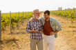 © BGStock72 - Two men stroll through a sunlit vineyard, sharing laughter and stories on a warm afternoon, surrounded by lush green vines