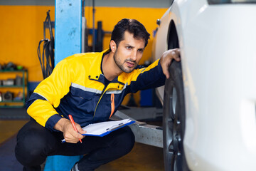 Mechanic checking checking the depth of car tire tread. Car maintenance and auto service garage