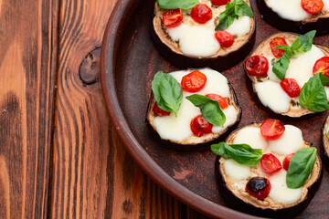 Wall Mural - Italian mini pizza . Aubergine (eggplant ) with mozzarella cheese and basil . On rustic background