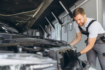 Wall Mural - Auto Mechanic Replacing Car Headlight in Modern Repair Shop Garage