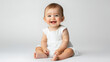 © basketman23 - Portrait of Happy Caucasian baby girl in white clothes, sitting with a grin ,isolated on a pure white background