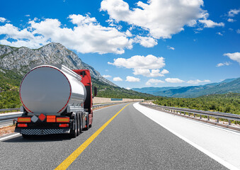 Wall Mural - Fuel truck on a picturesque road. A silver tank truck transports fuel.