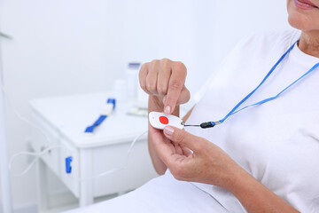 Sticker - Senior woman with emergency call button on bed in hospital, closeup