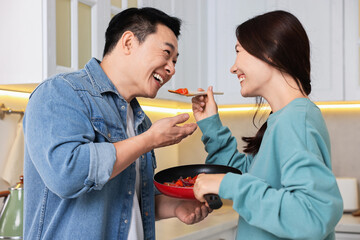 Canvas Print - Happy lovely couple cooking together in kitchen