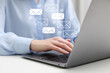 © New Africa - Woman using laptop at table, closeup. E-mail address signs and envelopes over computer