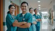 © VK Studio - A group of healthcare professionals in scrubs, smiling confidently in a hospital hallway with arms crossed, displaying team unity and dedication.