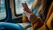 © alan - Woman holds phone on train.