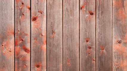 Aufkleber - A wooden background with red paint on it. The red paint is splattered all over the wood, giving it a rustic and aged appearance. The wood grain is visible, adding to the overall texture of the image