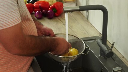 Wall Mural - Man is washing potato for cooking