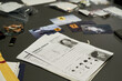 © pressmaster - Various pieces of evidence and files spread on table during criminal investigation process. Includes criminal profile documents, photos, and several labeled items