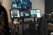 © pressmaster - Office space having multiple computer monitors displaying security footage and detailed information. Room filled with equipment and work essentials indicating active surveillance
