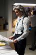 © pressmaster - Analyzing crime scene evidence in modern office setting, person in white shirt wearing FBI badge examining documents under focused lighting creating a professional atmosphere