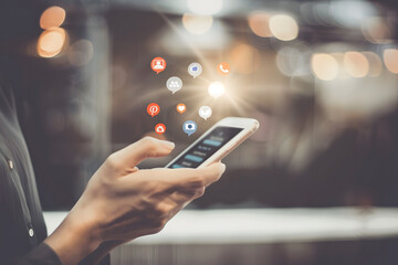 A close-up of a hand surfing the Internet on a mobile phone indoors