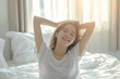 © dony - Portrait of beauty happy Asian woman awaking, wake up on the bed (sleep). Young beautiful Asian girl stretching her arms in fresh early morning, relax peaceful morning routine yawn concept banner