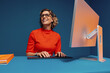 © Jacob Lund - Mature colleague working on computer with vibrant color blocking clothes