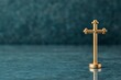 © AI_Imaginator - Golden cross on teal background with copy space