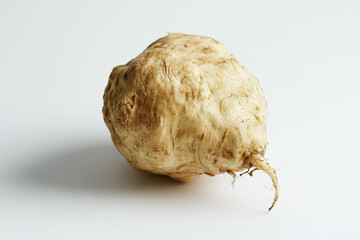 single maca root is lying on a white background