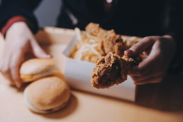 Wall Mural - close up focus woman hand hold fried chicken for eat,girl with fast food concept