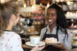 © Fotograf - A person holding a plate with a single cupcake, possibly for serving or display