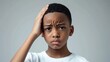© Ganesha88 - Black short hair boy holding his head in pain and frowning, close-up with pained expression due to earache