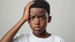 © Ganesha88 - Black short hair boy holding his head in pain and frowning, close-up with pained expression due to earache