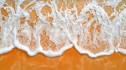 top view of the sandy beach with waves and foam, captured from above 