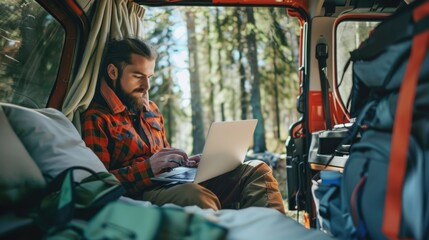 Wall Mural - a person typing away on their laptop from the backseat of a van, possibly on-the-go or during travel
